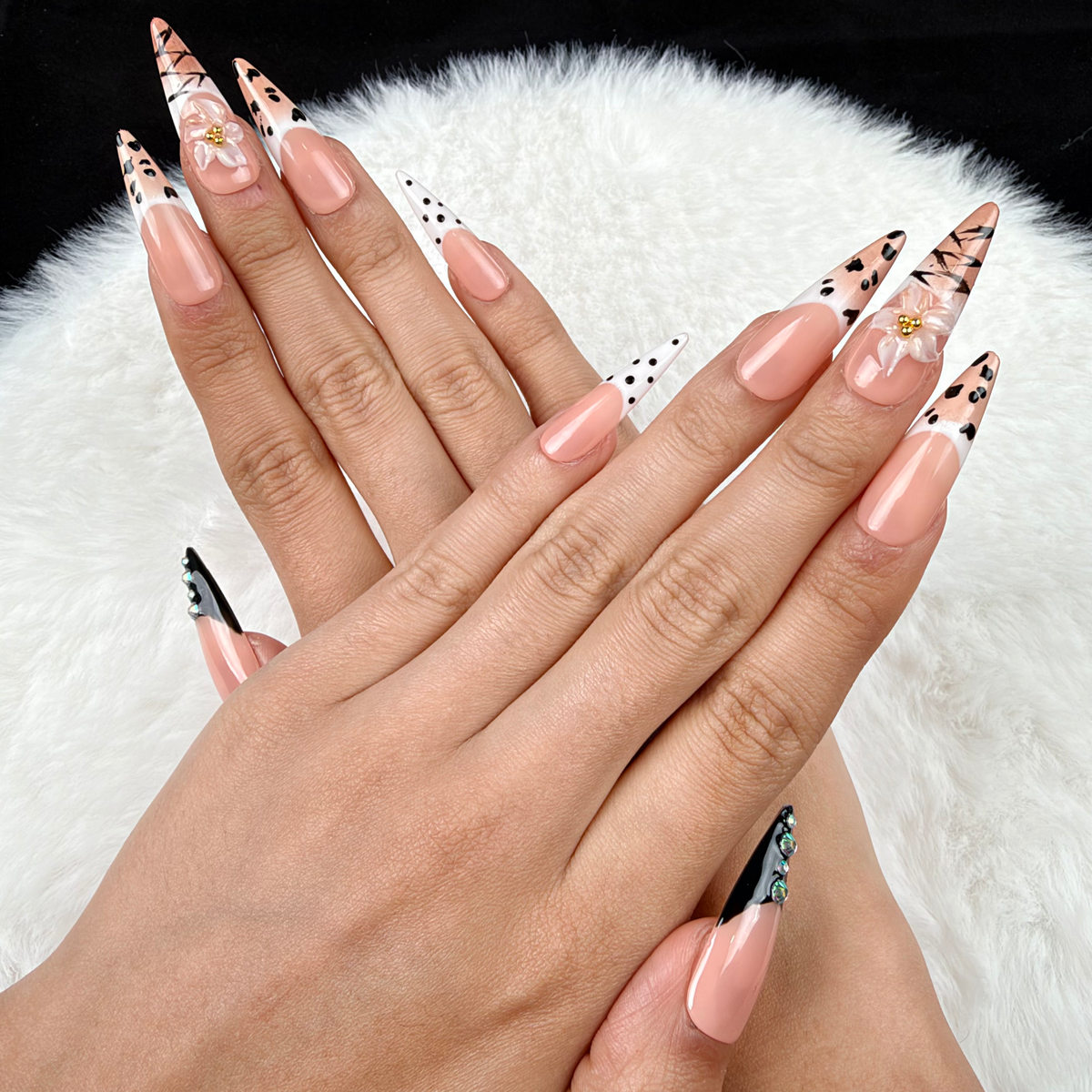 Hands wearing Noir Detail black and nude graphic French tip almond press-on nails