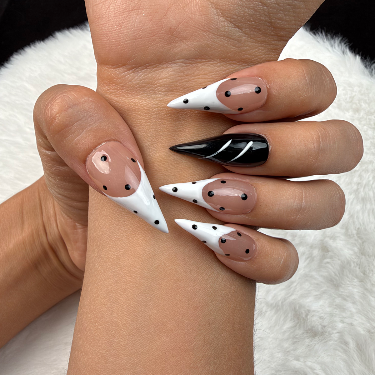 Close-up of hands wearing Ink Dots black and white polka dot stiletto press-on nails