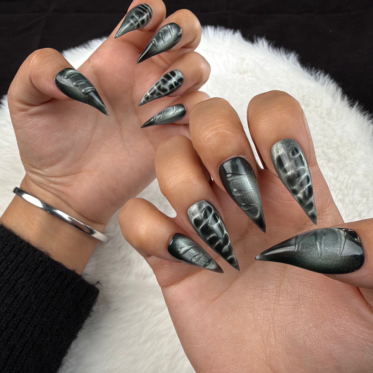 Hands wearing Chrome Shadow black and silver chrome stiletto press-on nails