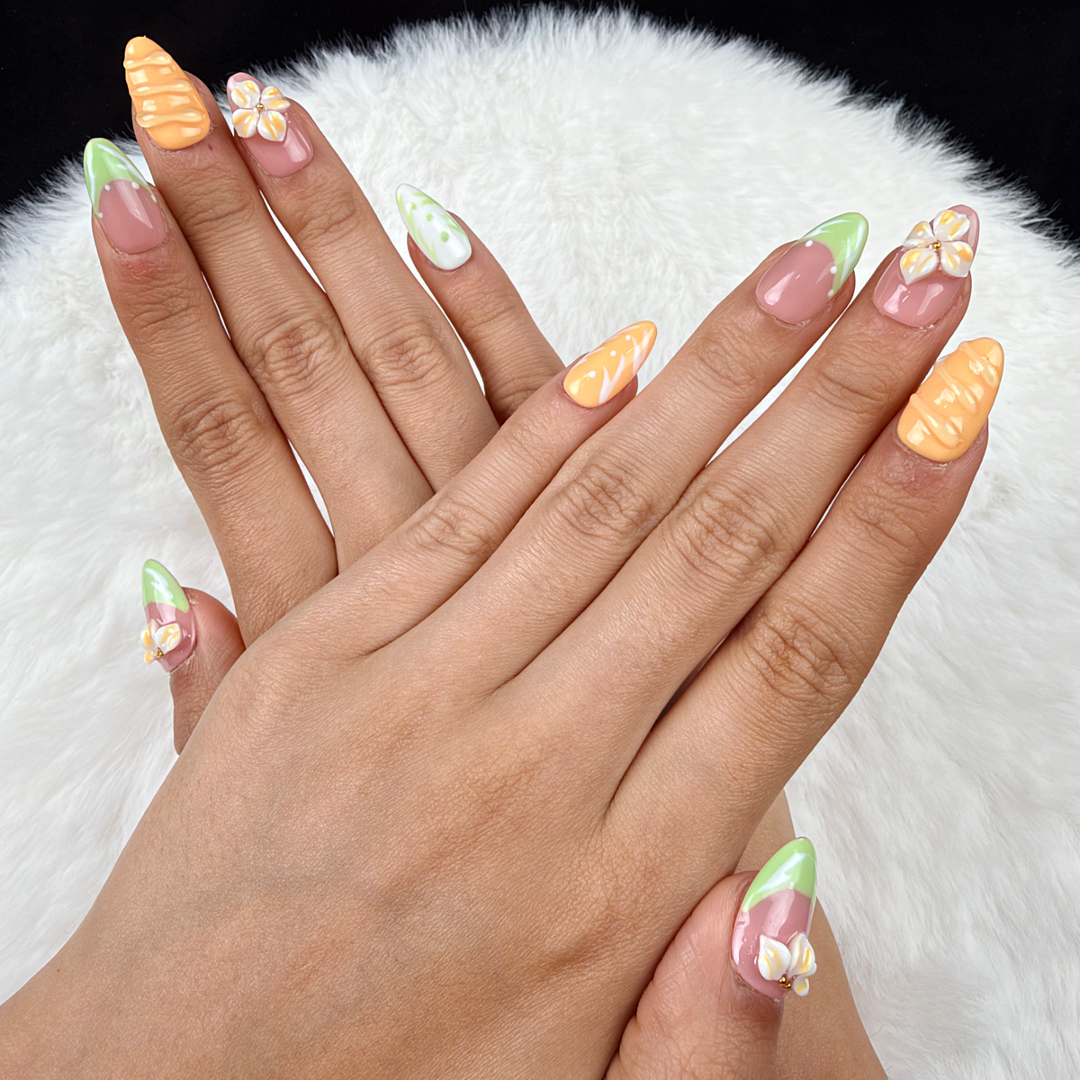 Hands wearing Citrus Blossom mint, pink and orange floral almond press-on nails