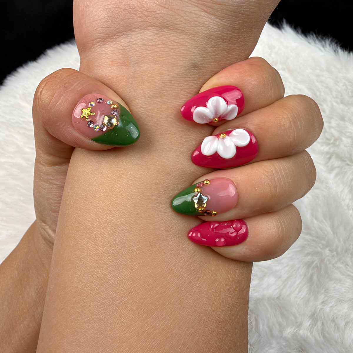 Close-up of hands wearing Holly Petals green and berry red Christmas floral almond press-on nails