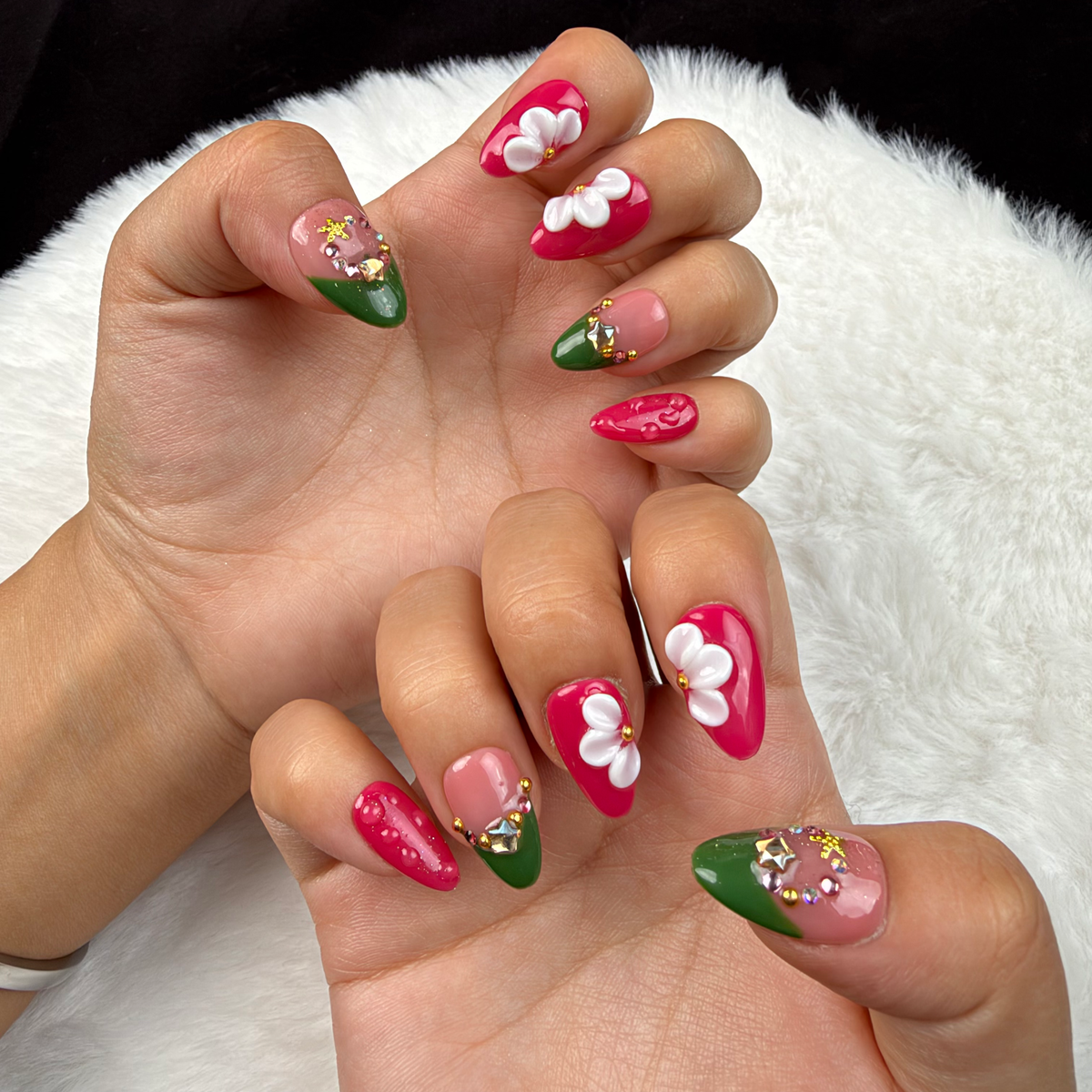 Hands wearing Holly Petals green and berry red Christmas floral almond press-on nails