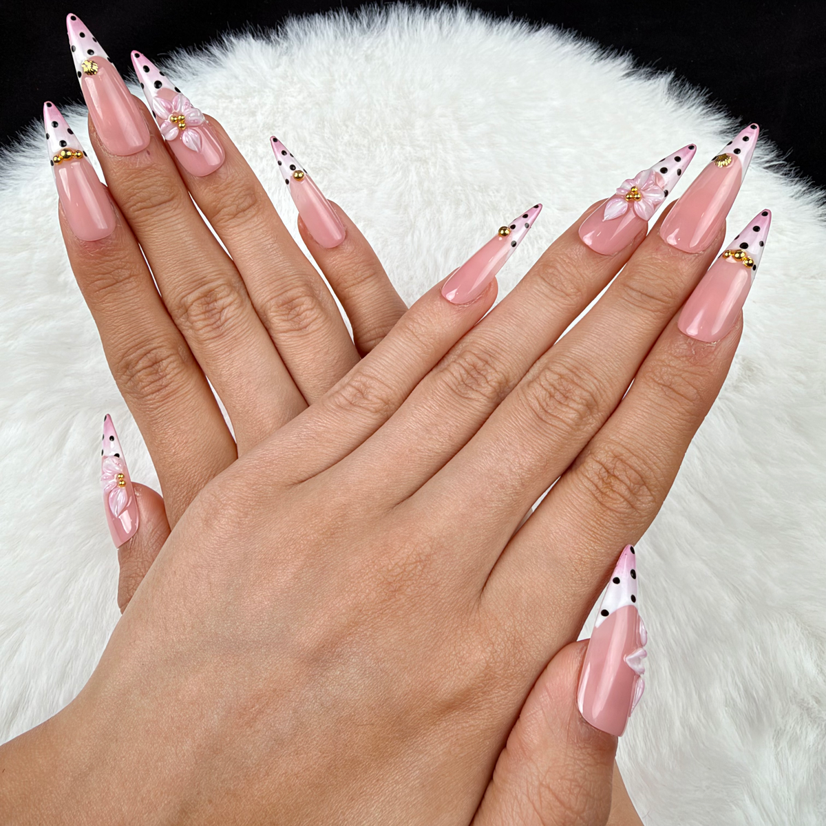 Hands wearing Blush Polka pink polka dot French tip floral almond press-on nails