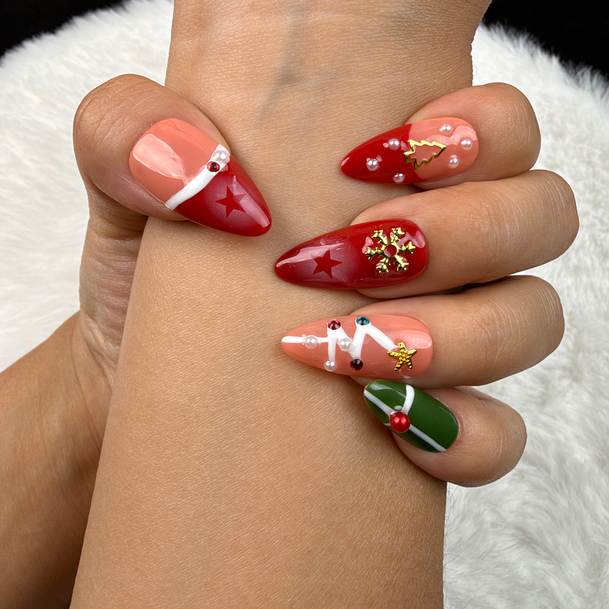 Close-up of hands wearing Christmas Keepsakes red, green and nude French tip Christmas almond press-on nails