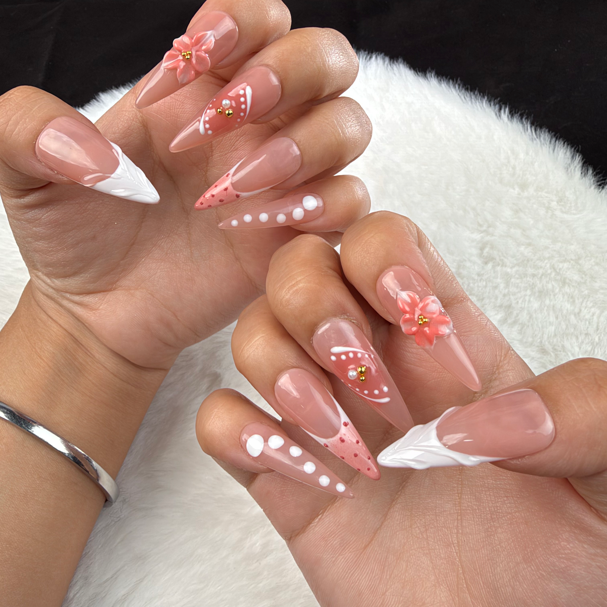 Close-up of hands wearing Peach Bloom nude pink and white French floral almond press-on nails