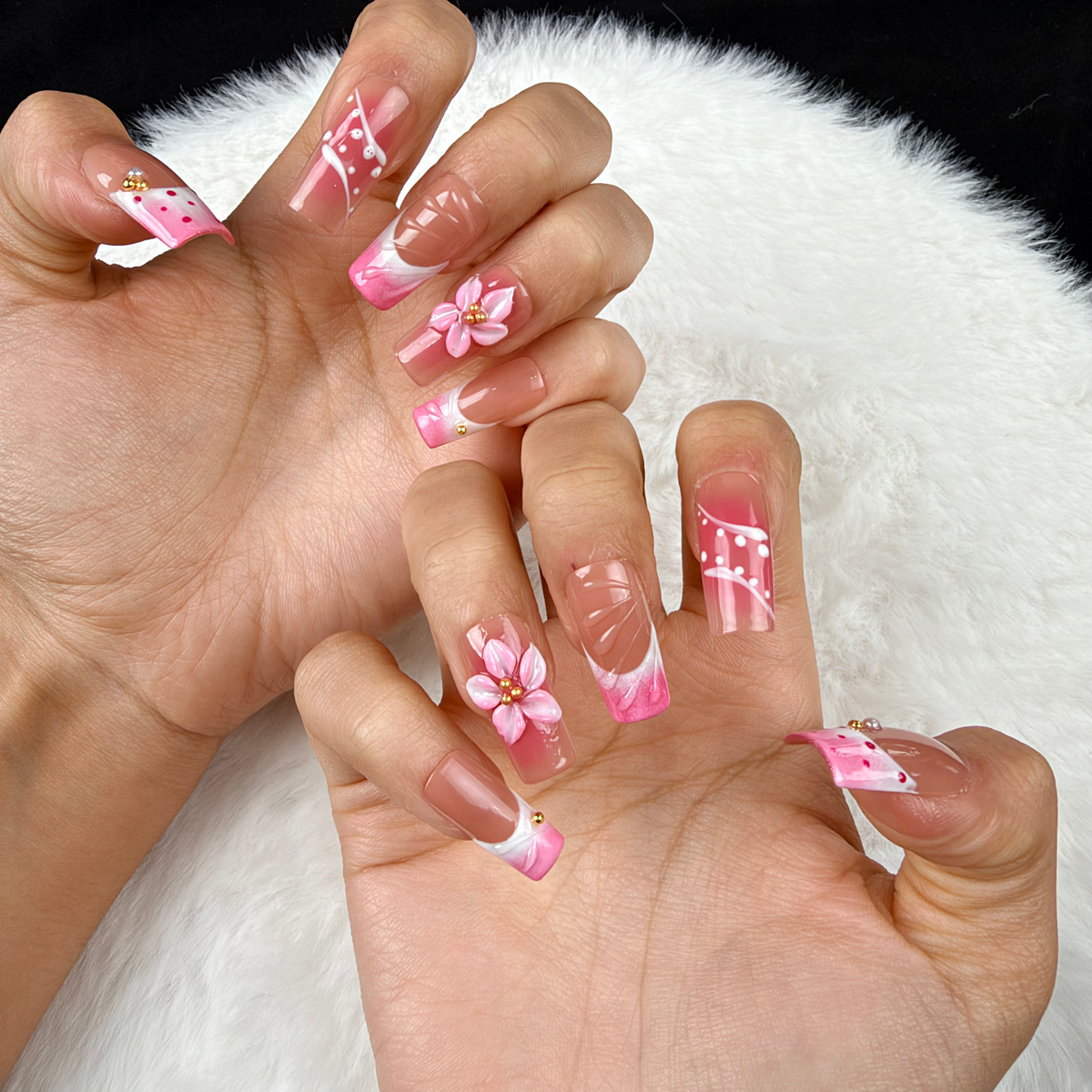 Close-up of hands wearing Rose Trellis pink floral and white linework square press-on nails