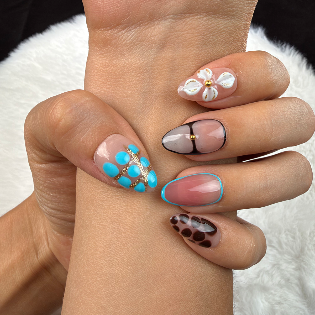Close-up of hands wearing Turquoise Mix turquoise, leopard print and floral almond press-on nails