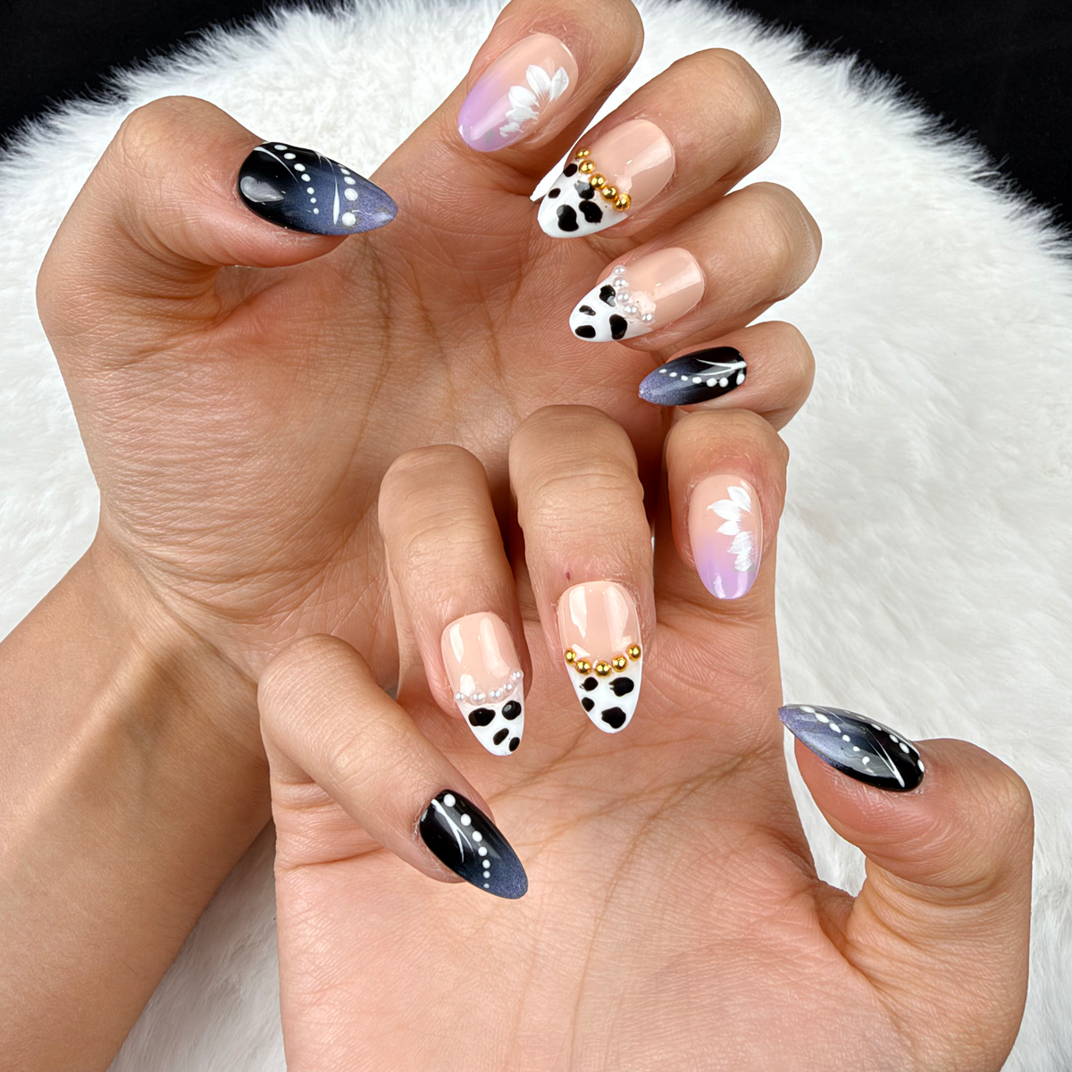 Close-up of hands wearing Monochrome Meadow black and white floral almond press-on nails