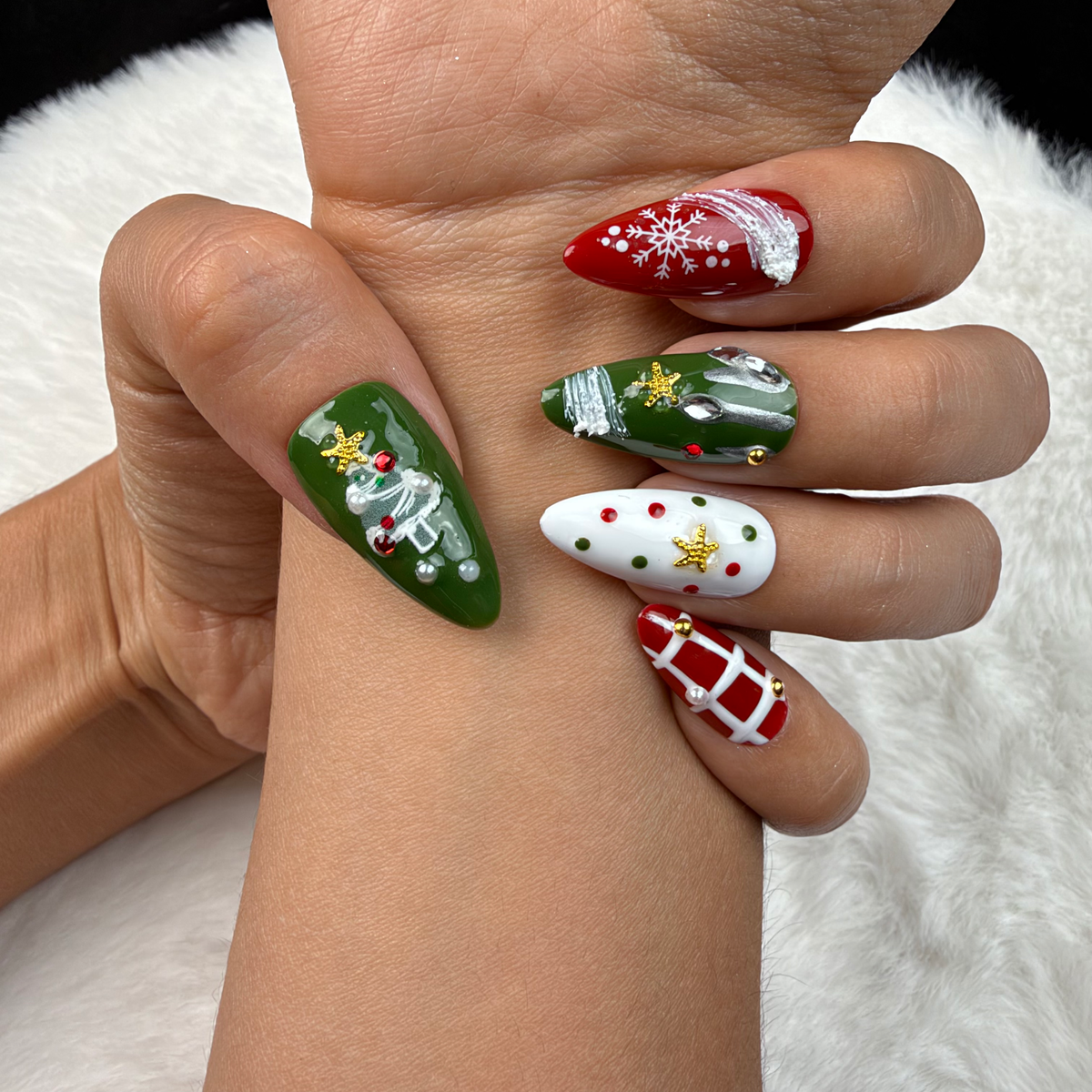 Close-up of hands wearing Winter Parcel red and green ribbon and plaid Christmas almond press-on nails
