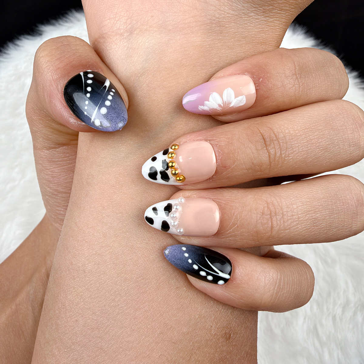 Detail shot of Monochrome Meadow black and white floral almond press-on nails on hand