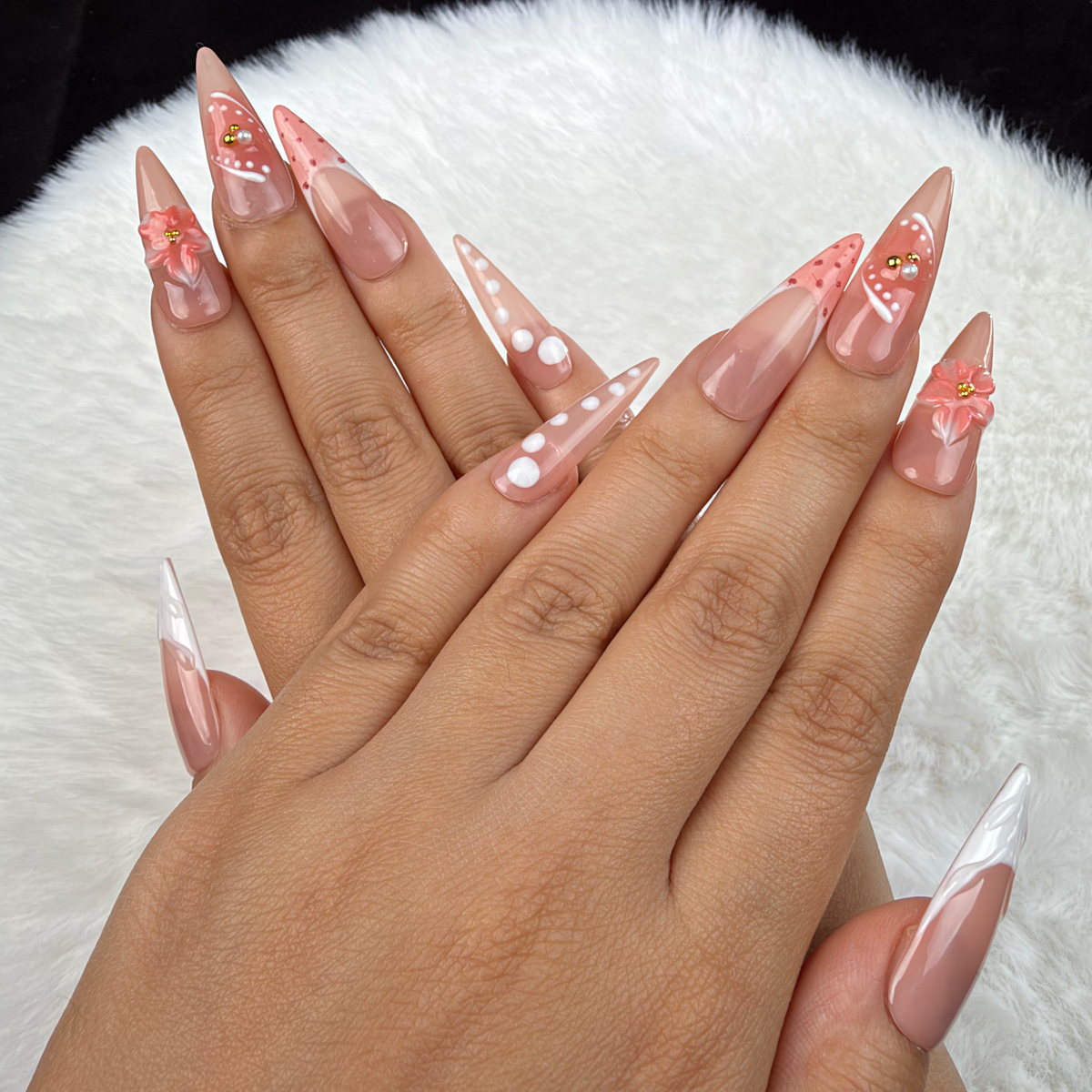 Hands wearing Peach Bloom nude pink and white French floral almond press-on nails