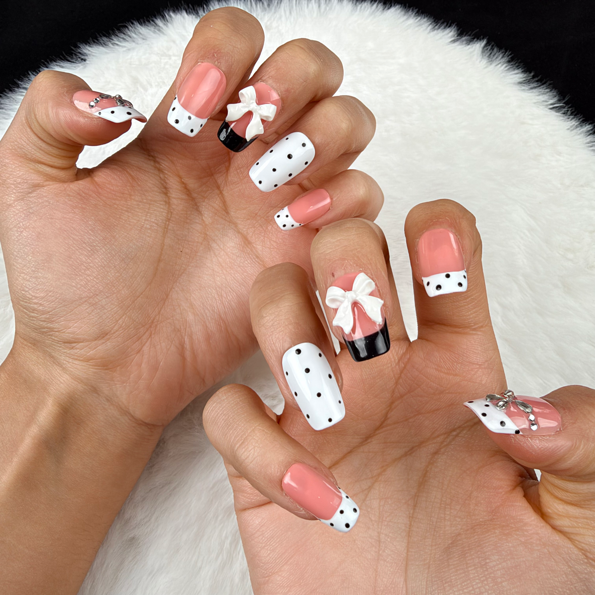 Close-up of hands wearing Polka Bow black and white polka dot bow square press-on nails