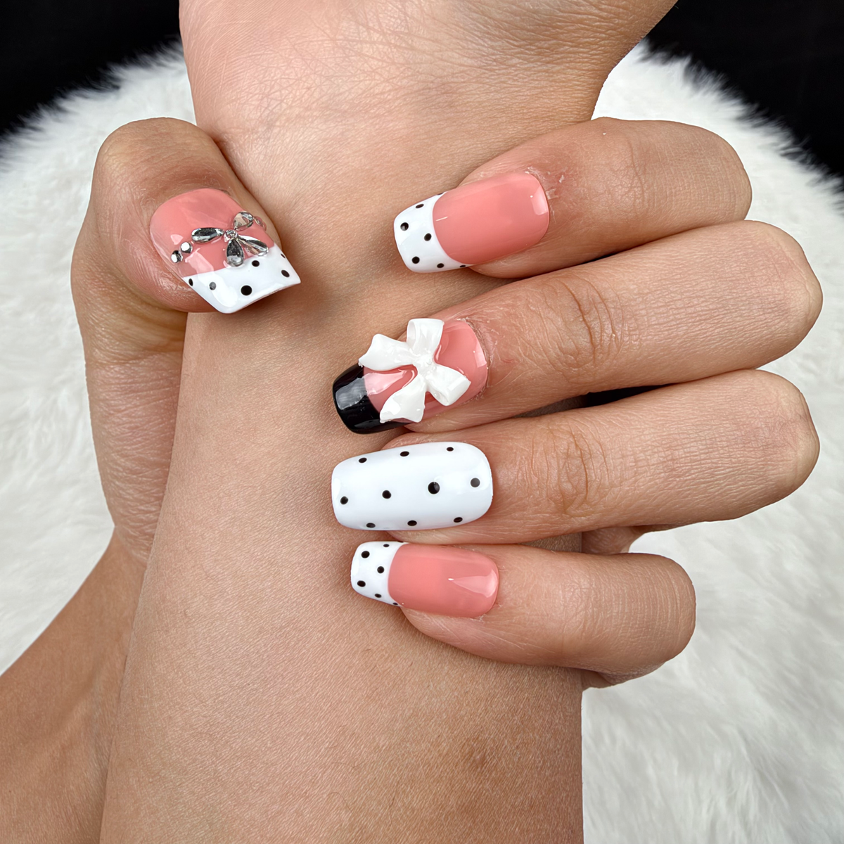 Detail shot of Polka Bow black and white polka dot bow square press-on nails on hand