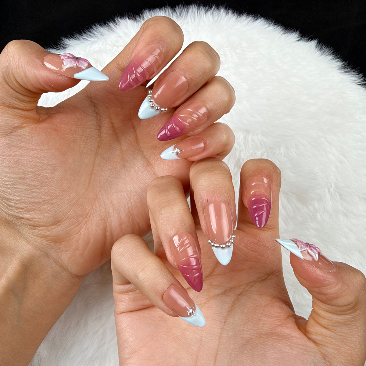 Close-up of hands wearing Rose Lattice pink French tip almond press-on nails with raised flowers