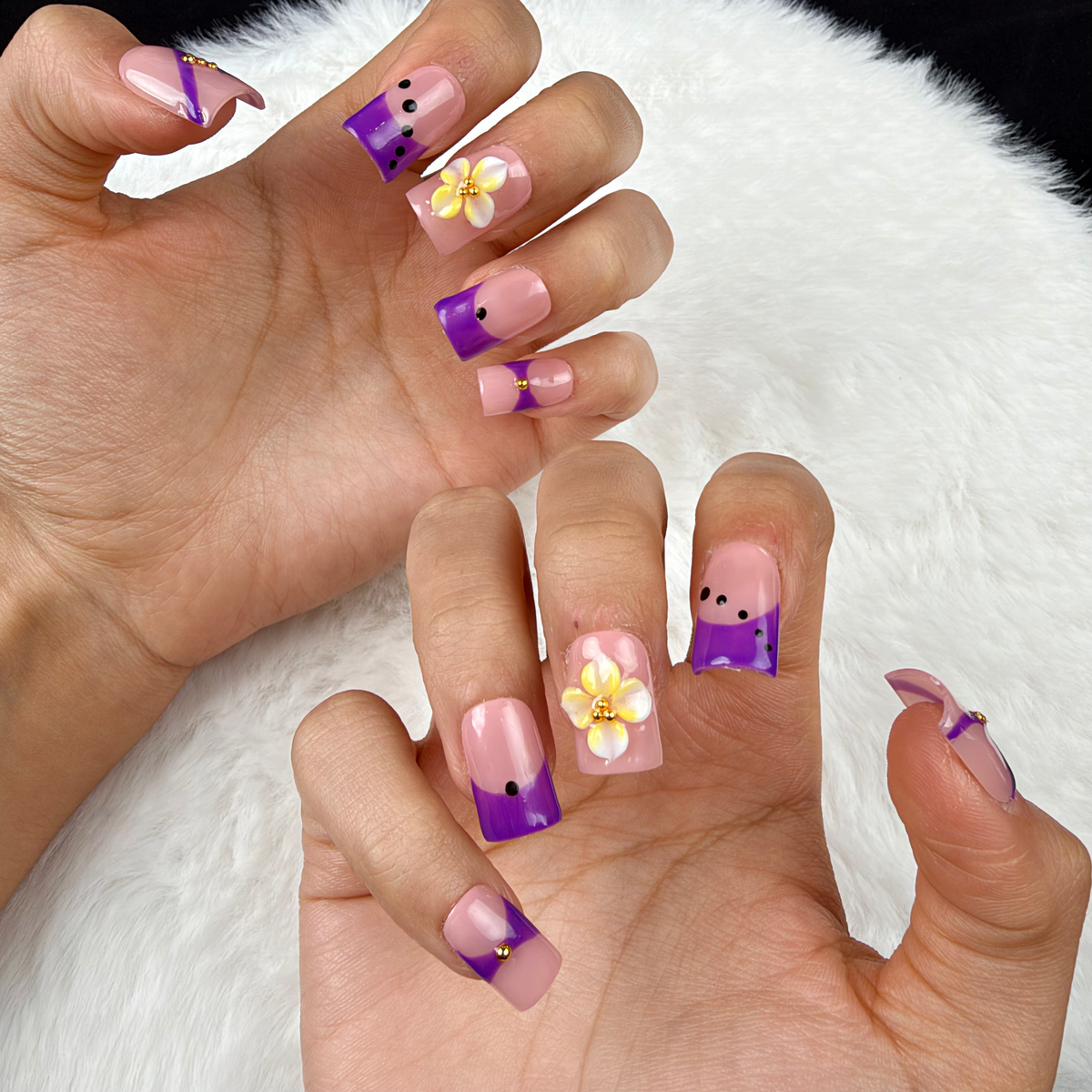 Close-up of hands wearing Violet Ribbon purple and yellow floral square press-on nails