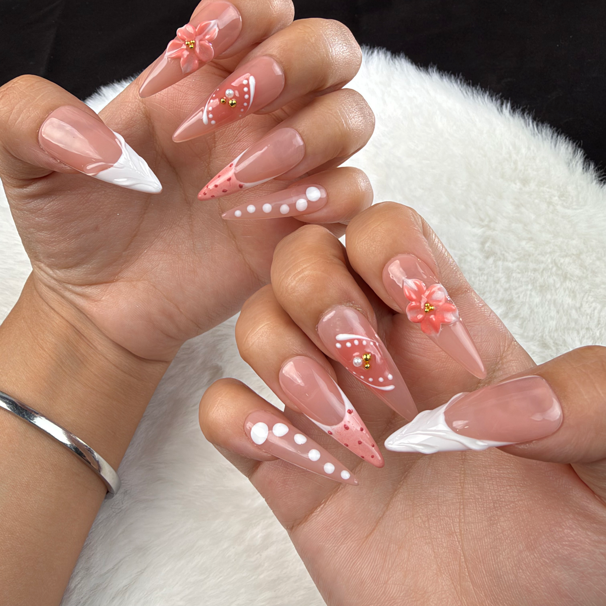 Hands wearing Peach Bloom nude pink and white French floral almond press-on nails