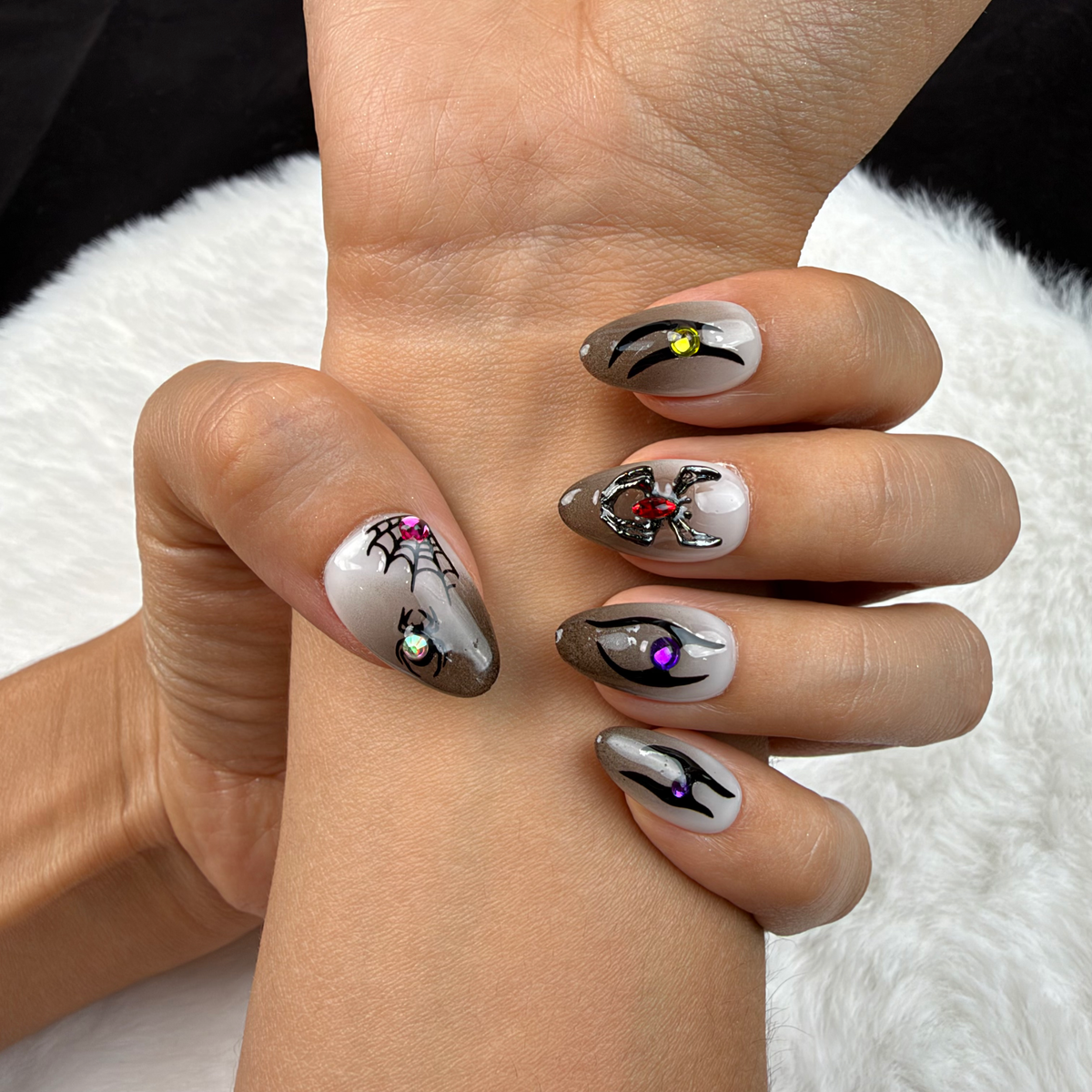 Close-up of hands wearing Midnight Creepers grey spider Halloween almond press-on nails