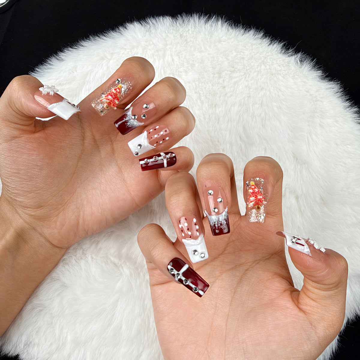 Detail shot of Winter Rose burgundy glitter and white snowflake Christmas square press-on nails on hand