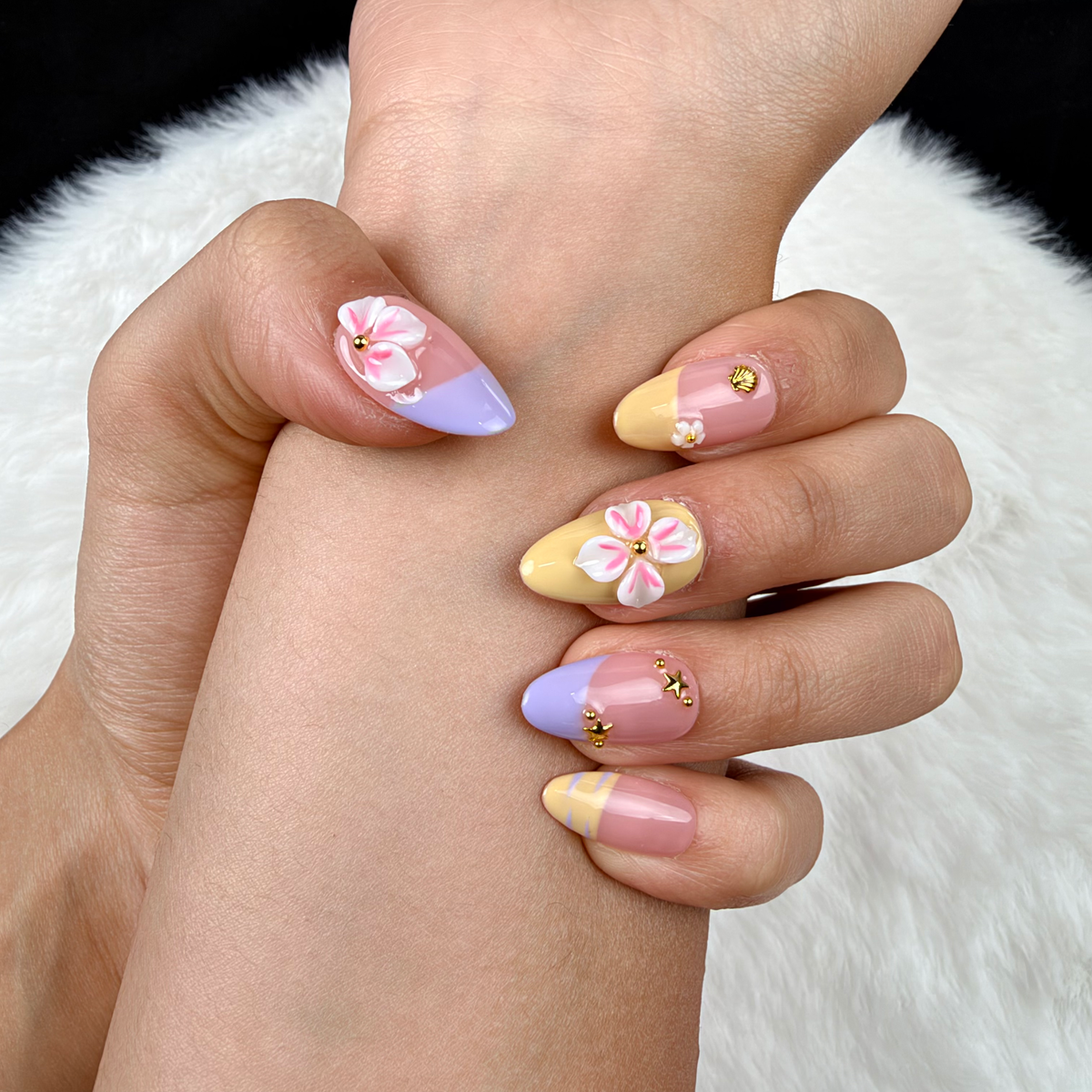 Detail shot of Lilac Lemon lilac and yellow French tip floral almond press-on nails on hand