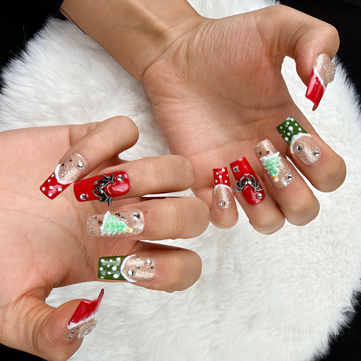 Detail shot of Gingerbread Party red, green and glitter Christmas square press-on nails with gingerbread and tree designs on hand