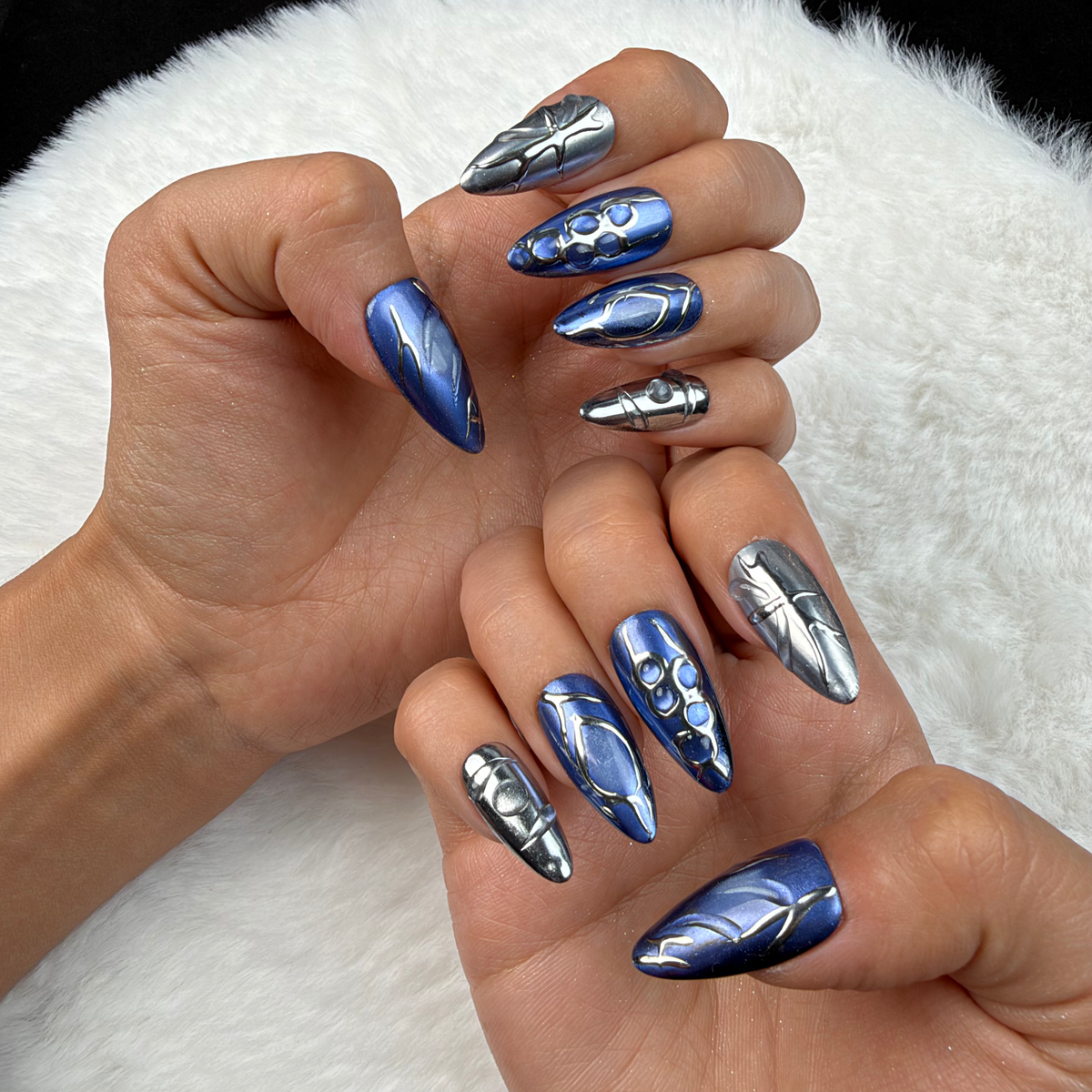 Hands wearing Sapphire Wire blue and silver abstract stiletto press-on nails