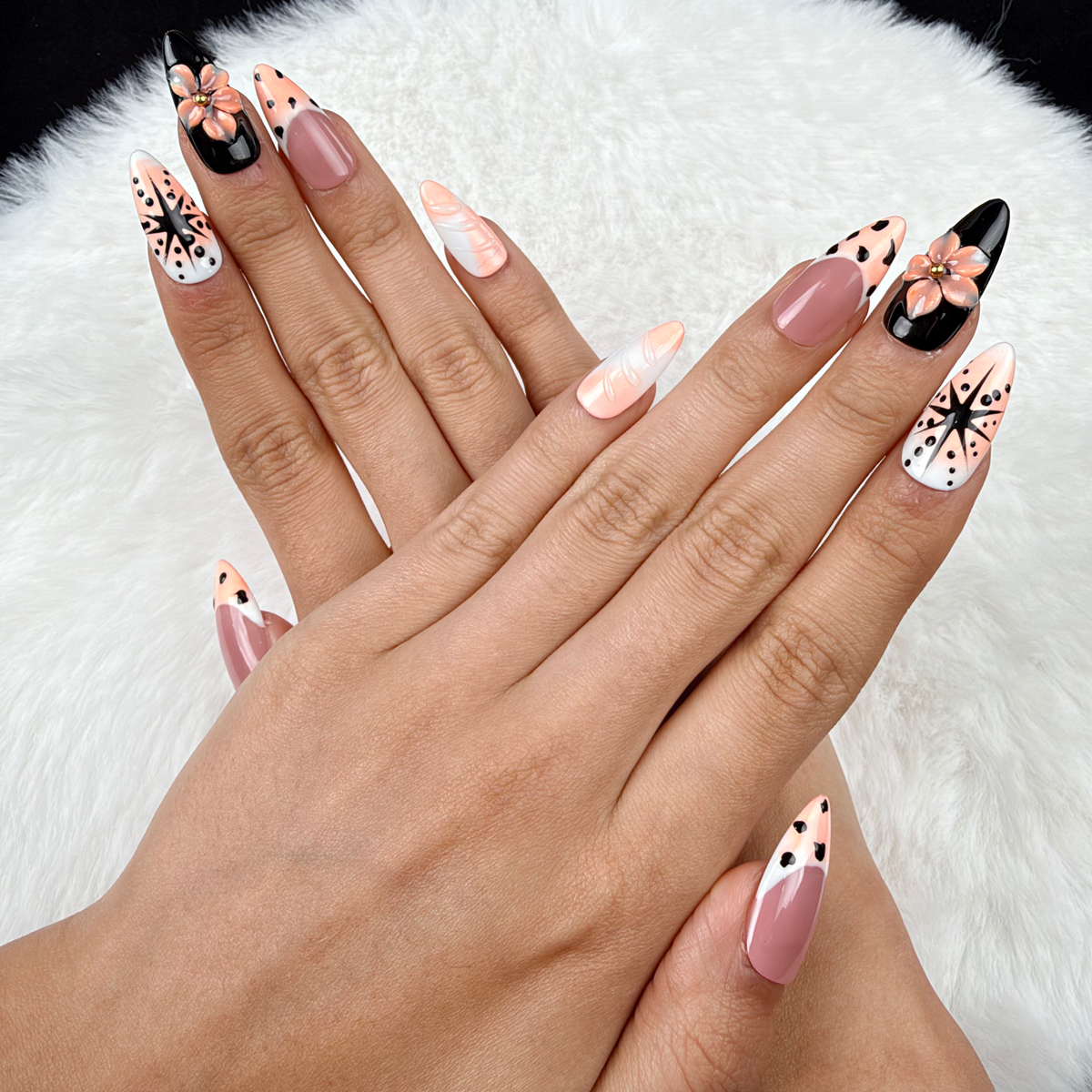 Hands wearing Peach Graphic Bloom peach and black floral almond press-on nails