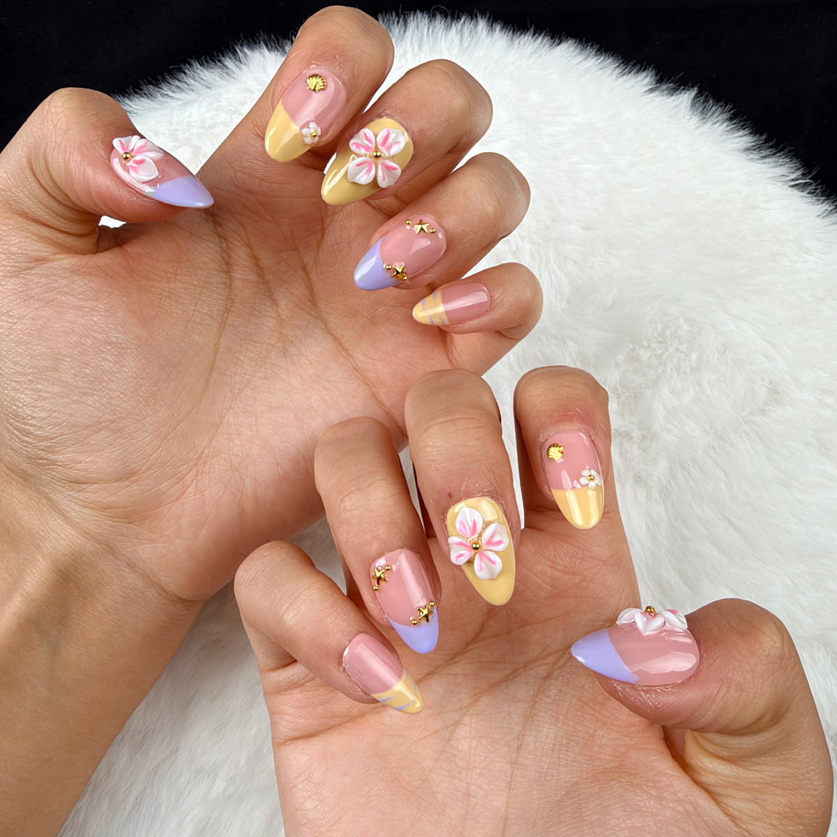Close-up of hands wearing Lilac Lemon lilac and yellow French tip floral almond press-on nails