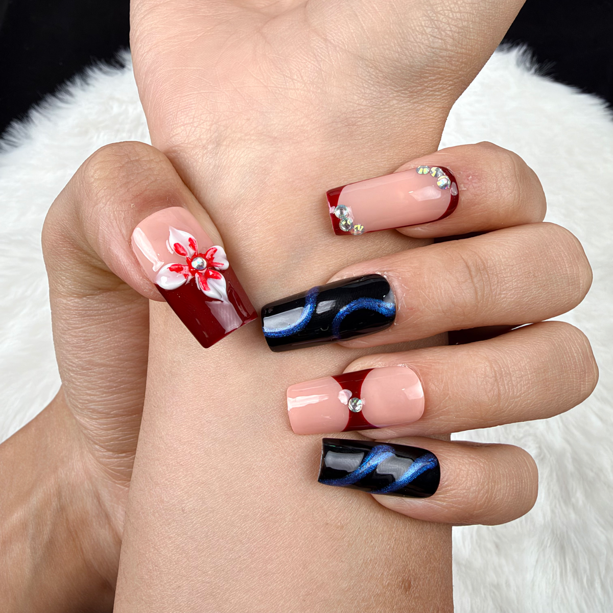 Detail shot of Wine Ribbon burgundy and navy bow square press-on nails on hand