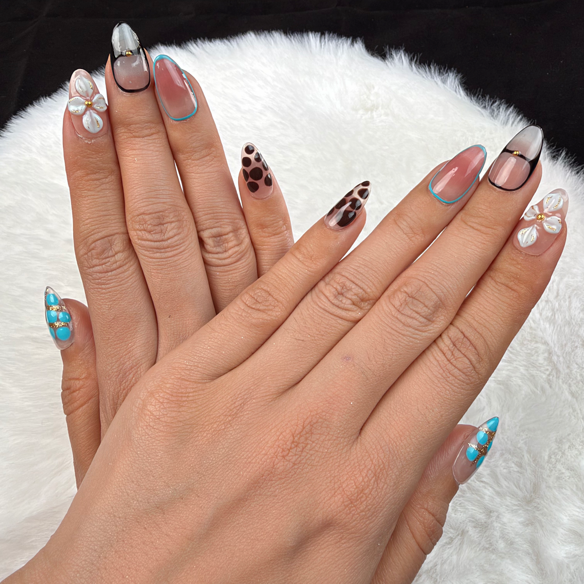 Detail shot of Turquoise Mix turquoise, leopard print and floral almond press-on nails on hand