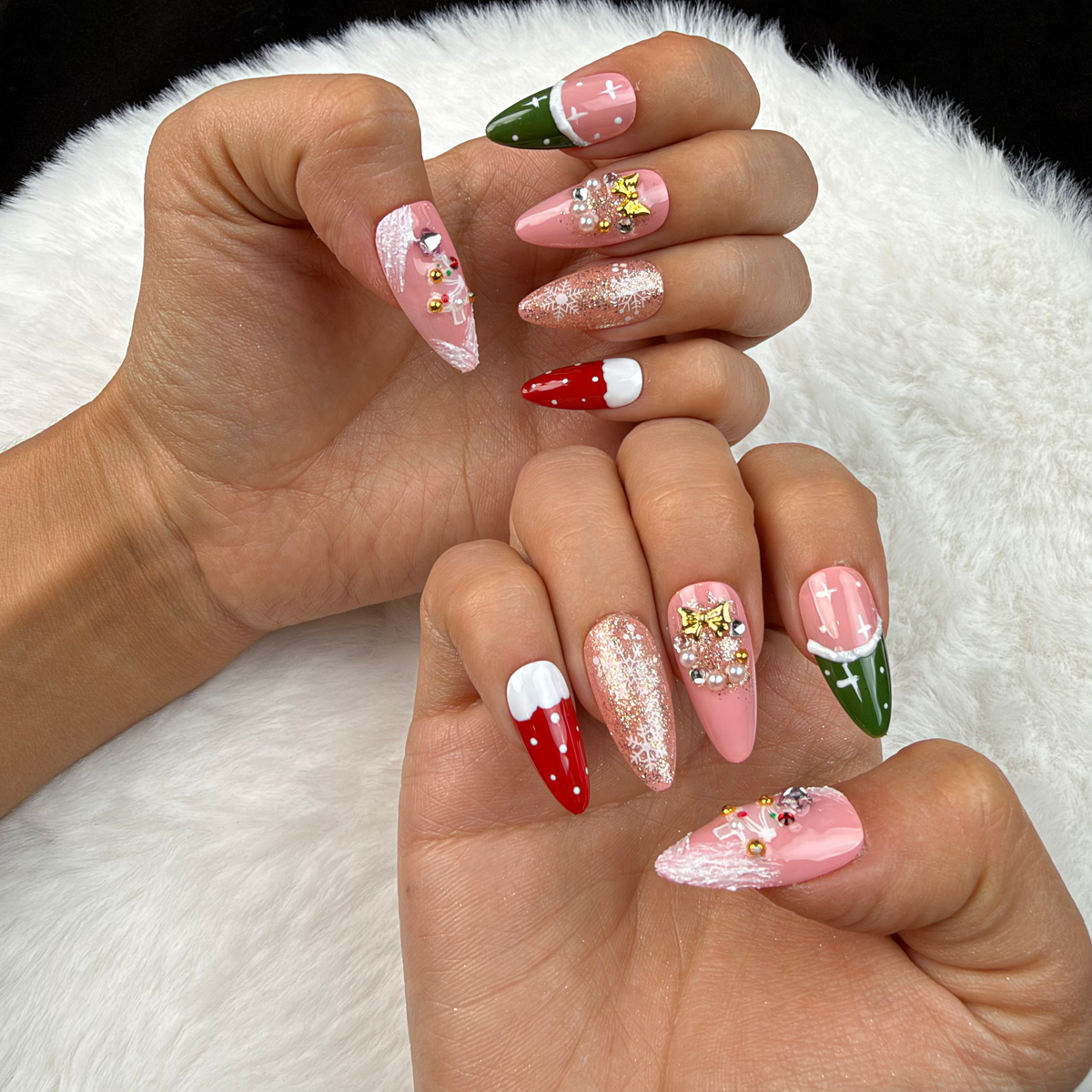 Hands wearing Pink Noel pink, red and green Christmas almond press-on nails