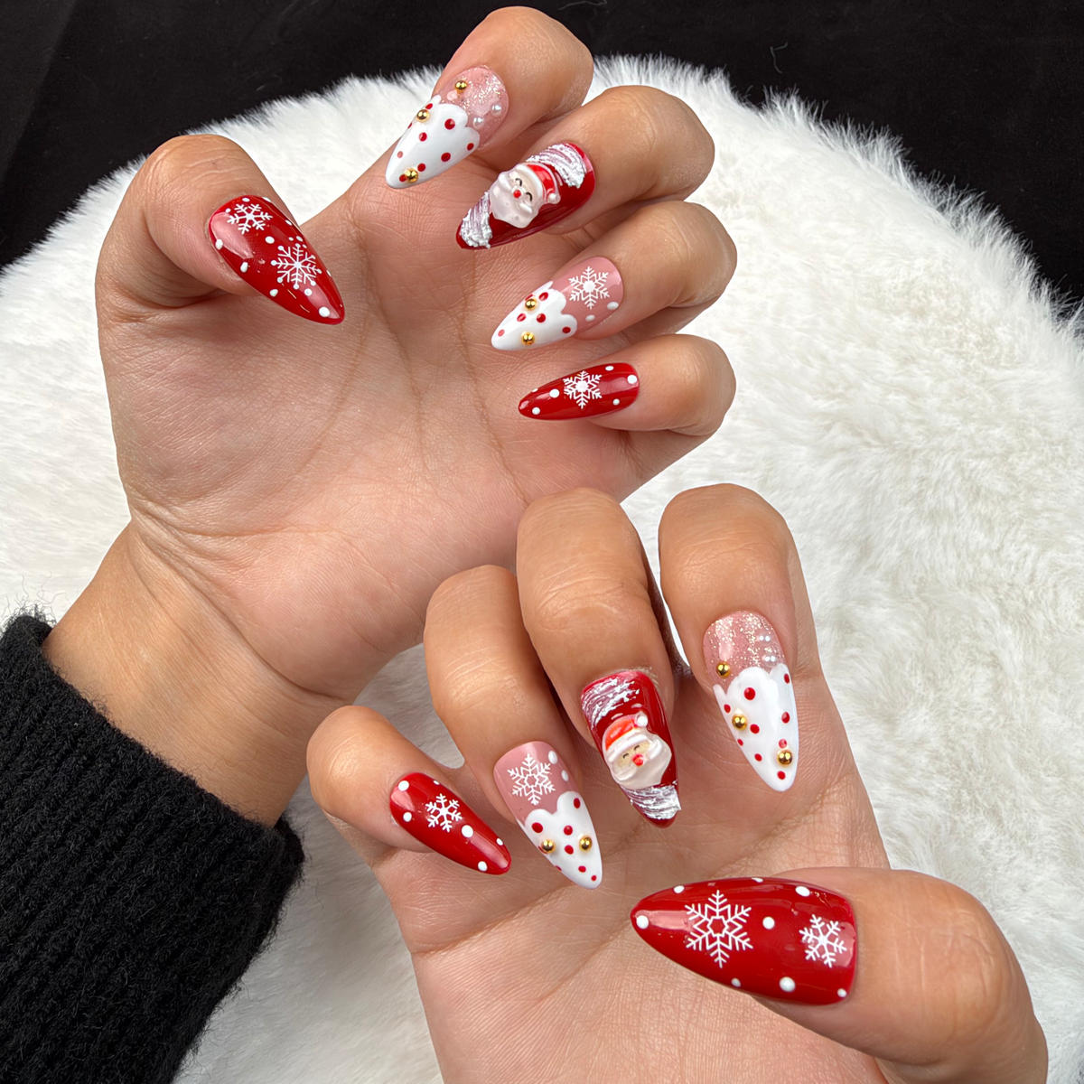 Hands wearing Santa Snow red and white Santa Christmas almond press-on nails