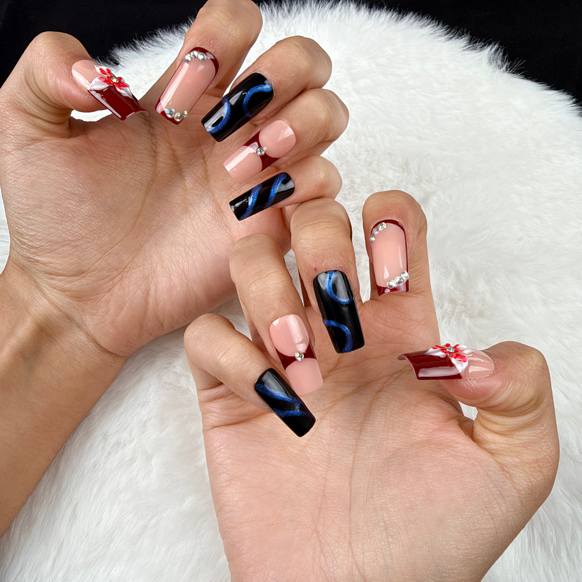 Close-up of hands wearing Wine Ribbon burgundy and navy bow square press-on nails