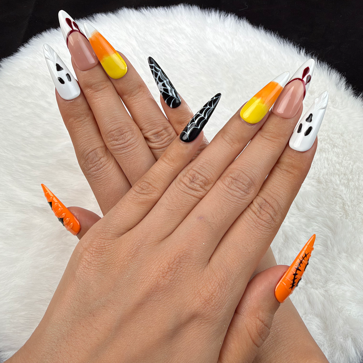 Hands wearing Haunted Parade ghost, pumpkin and spiderweb Halloween stiletto press-on nails