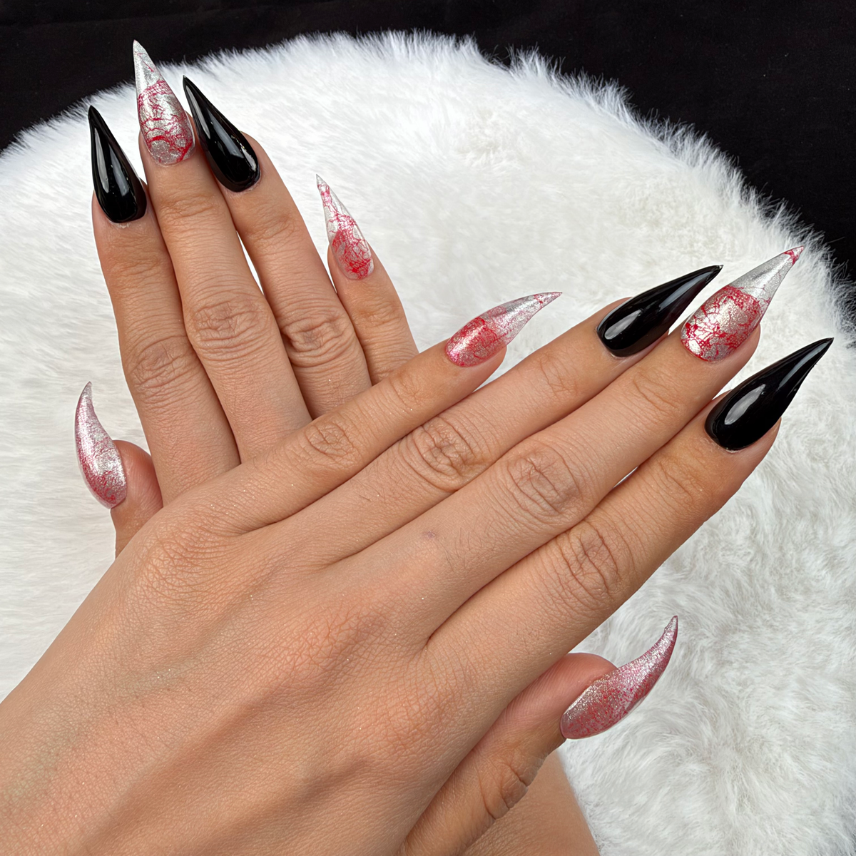 Detail shot of Rose Static pink and silver crackle and black stiletto press-on nails on hand