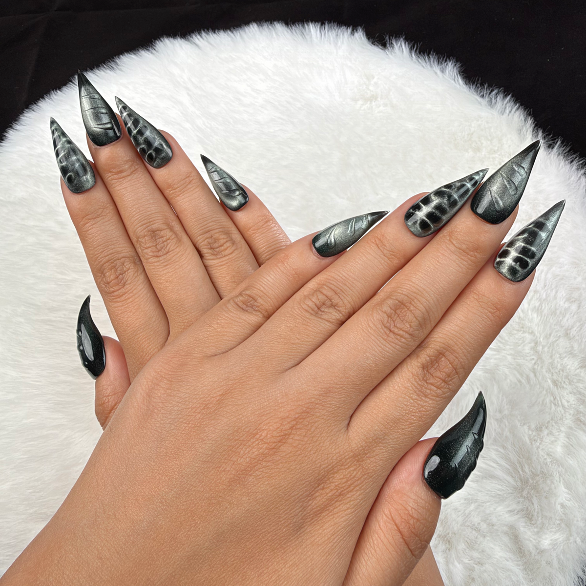 Detail shot of Chrome Shadow black and silver chrome stiletto press-on nails on hand