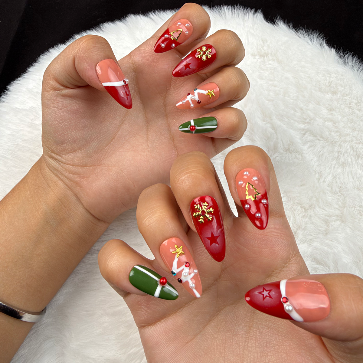 Hands wearing Christmas Keepsakes red, green and nude French tip Christmas almond press-on nails