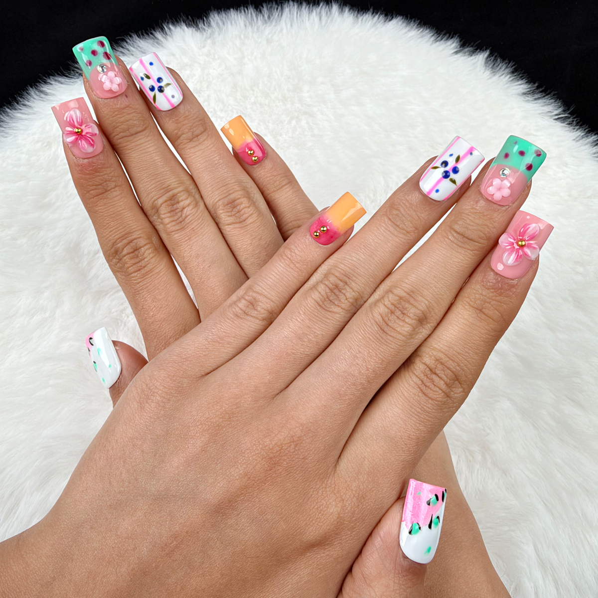 Hands wearing Pastel Flower Mix pink, mint and blue floral square press-on nails