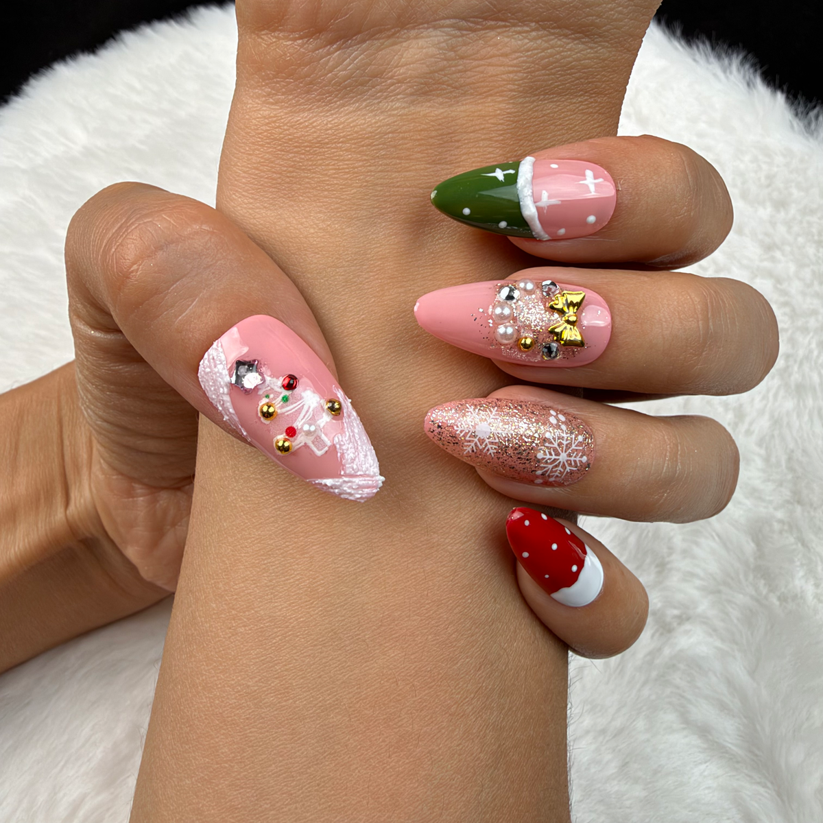 Close-up of hands wearing Pink Noel pink, red and green Christmas almond press-on nails