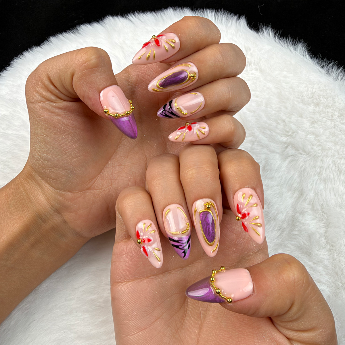 Hands wearing Amethyst Bloom purple and gold floral almond press-on nails