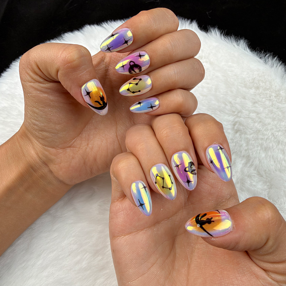 Close-up of hands wearing Aurora Signs iridescent celestial almond press-on nails