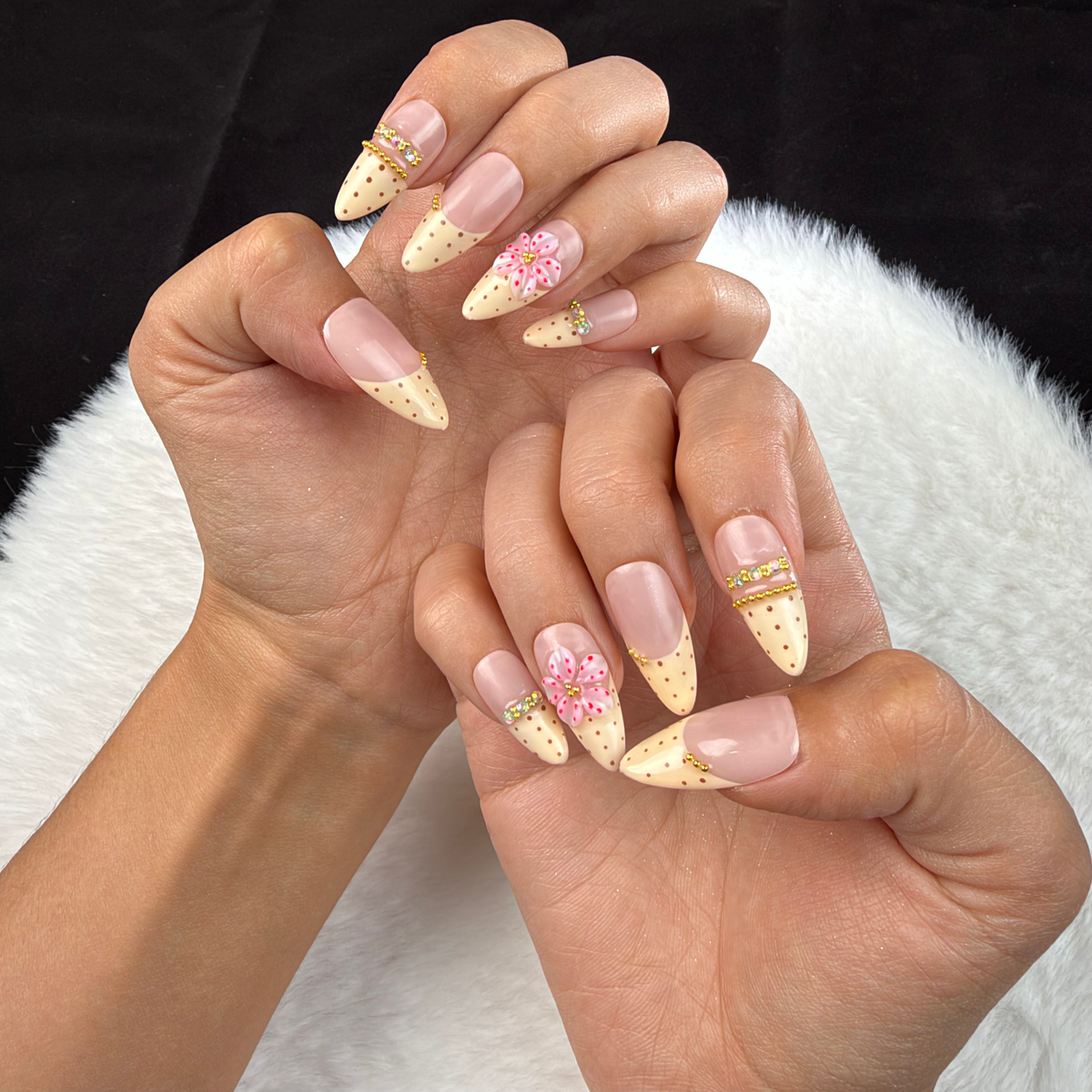 Hands wearing Vanilla Bloom cream French and pink floral almond press-on nails