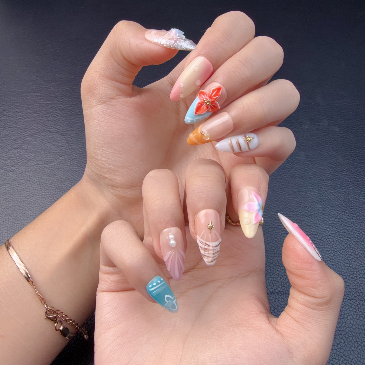 Hands wearing Pastel tropical shell and floral almond press-on nails