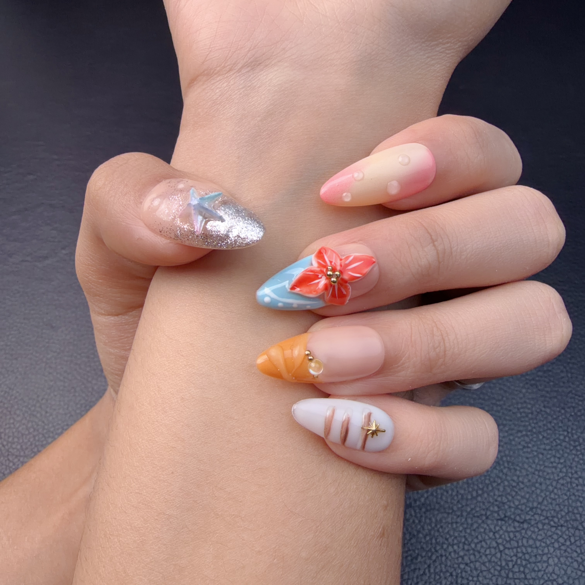 Hands wearing Pastel tropical shell and floral almond press-on nails