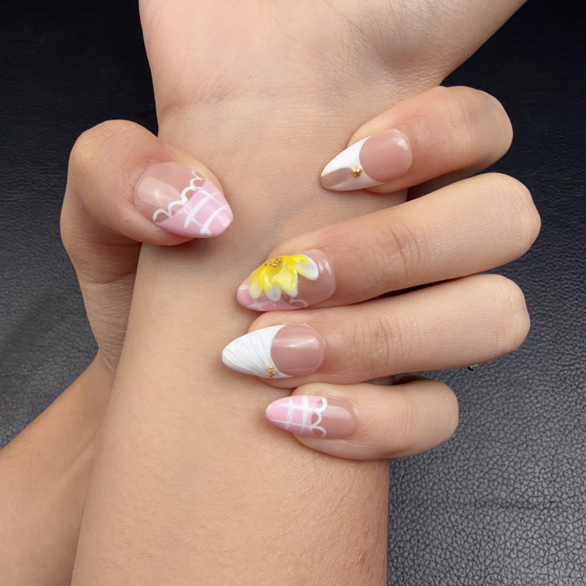 Hands wearing Buttercream Bloom pink, white and yellow 3D floral medium almond press-on nails