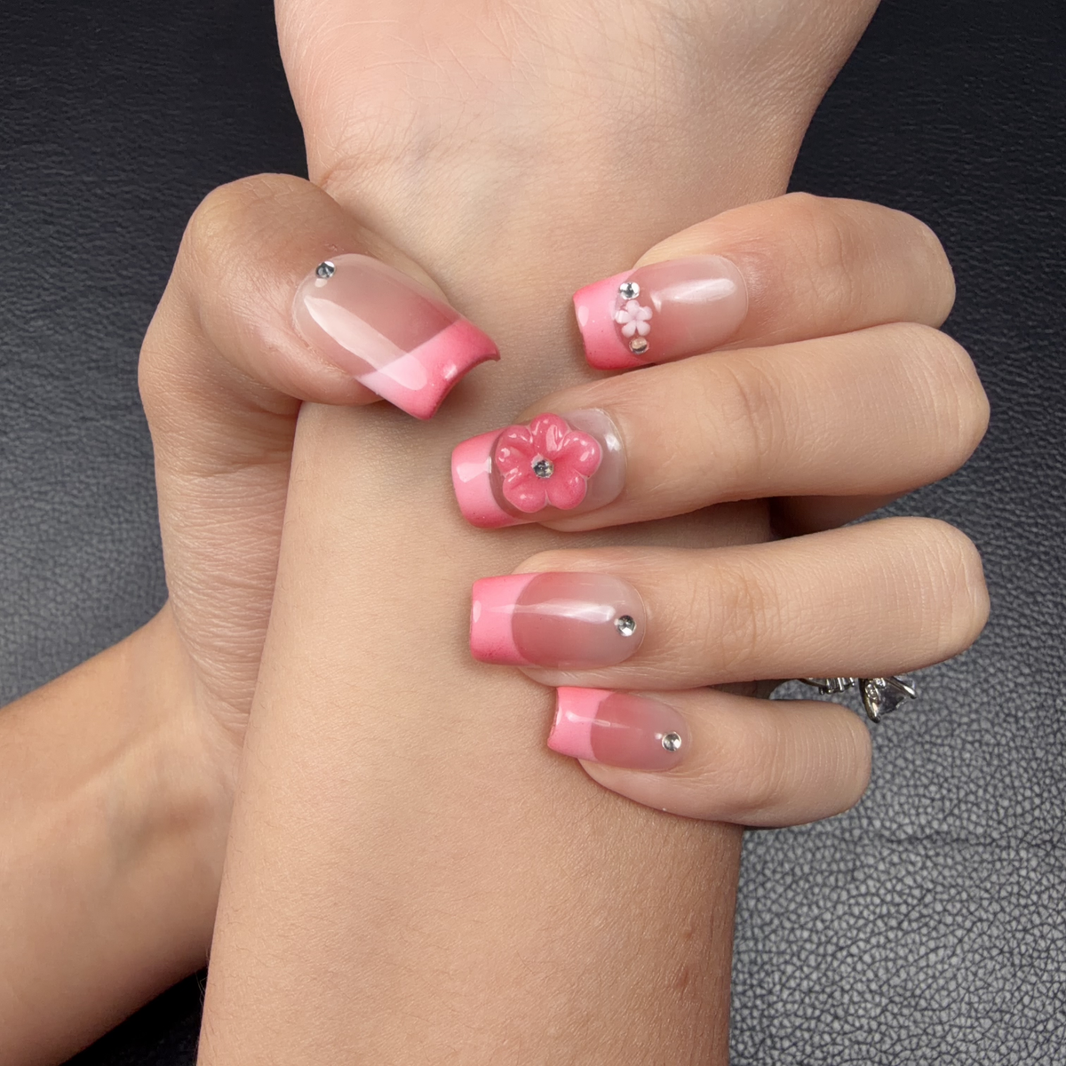 Hands wearing Rose pink French tip 3D floral medium square press-on nails