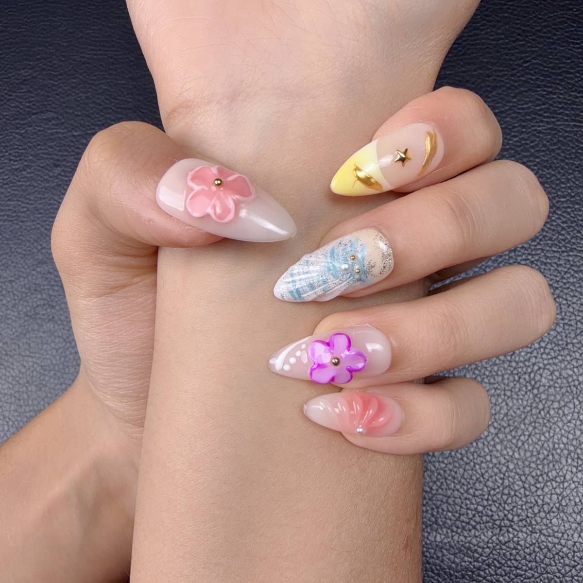 Hands wearing Aqua Bloom iridescent pastel floral long almond press-on nails