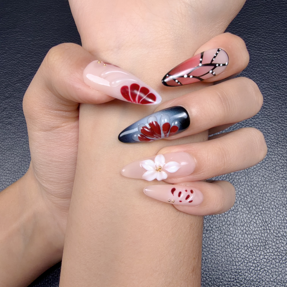 Hands wearing Crimson Wings deep red and black butterfly 3D floral press-on nails