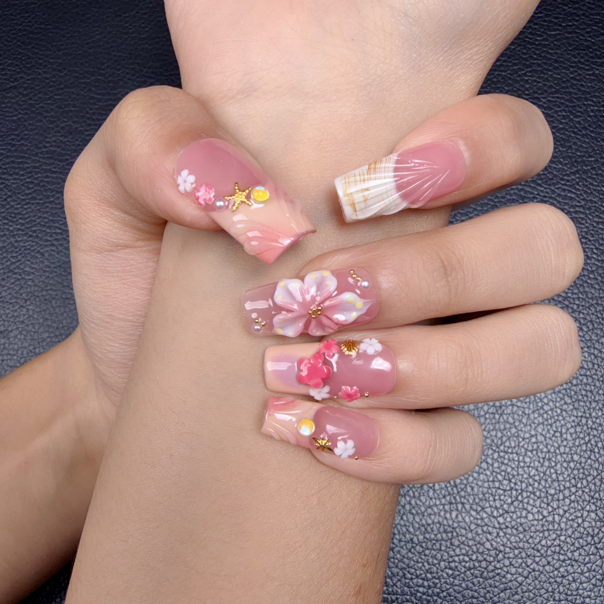 Hands wearing Lily Blush pink 3D floral square press-on nails with pearls and gold accents
