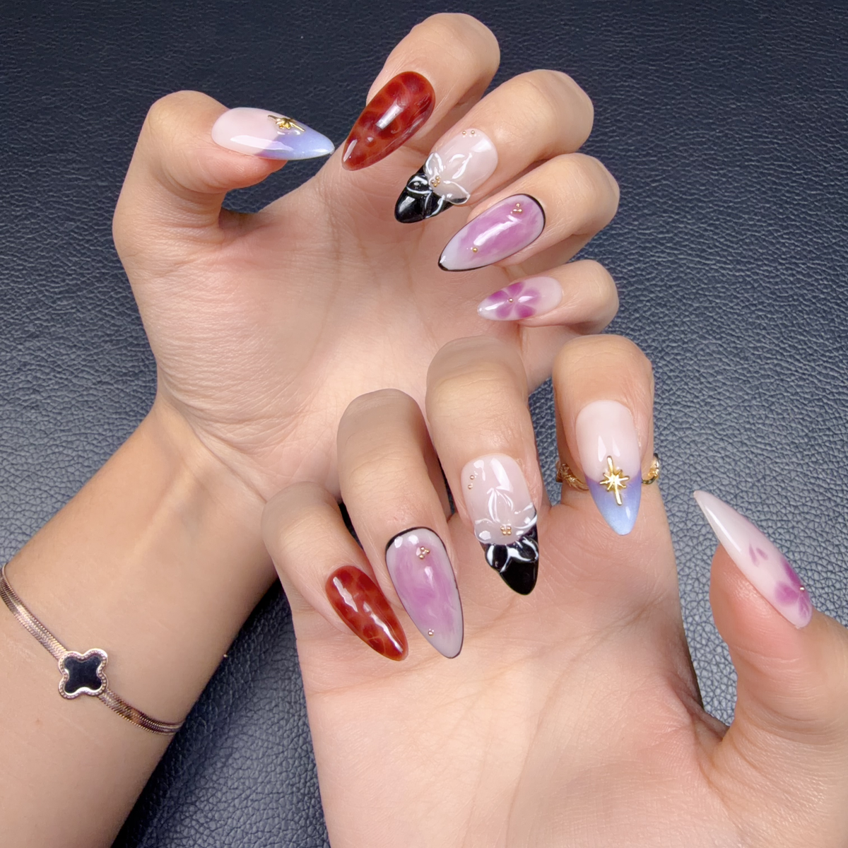 Hands wearing Violet Tortoise lavender tortoiseshell floral bow medium almond press-on nails