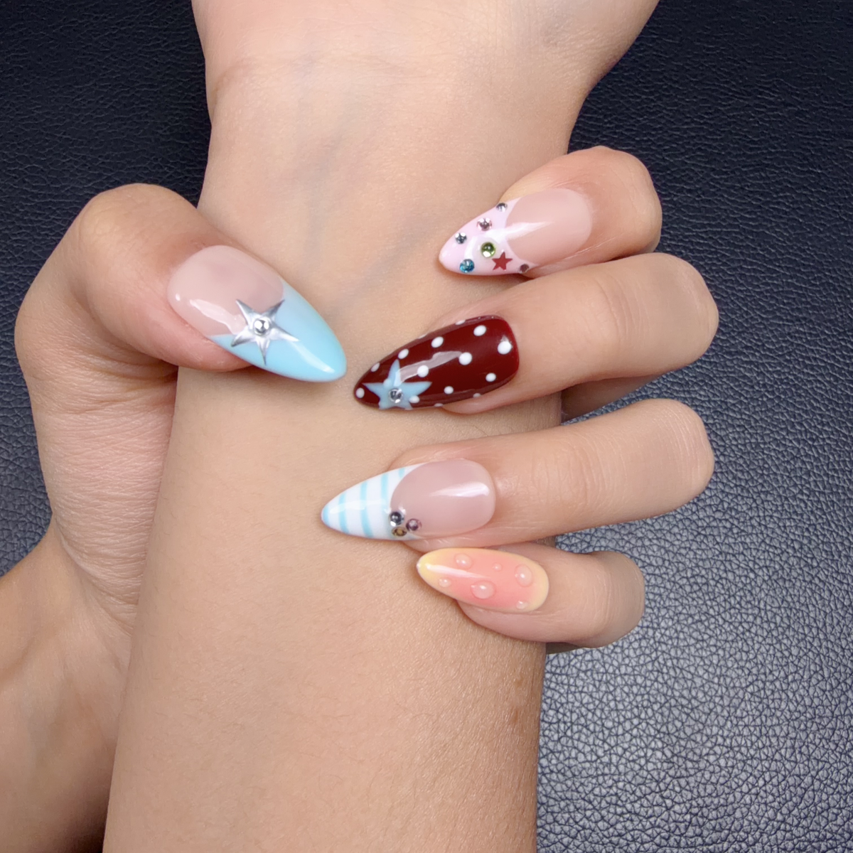 Hands wearing Rainbow pastel graphic accent almond press-on nails